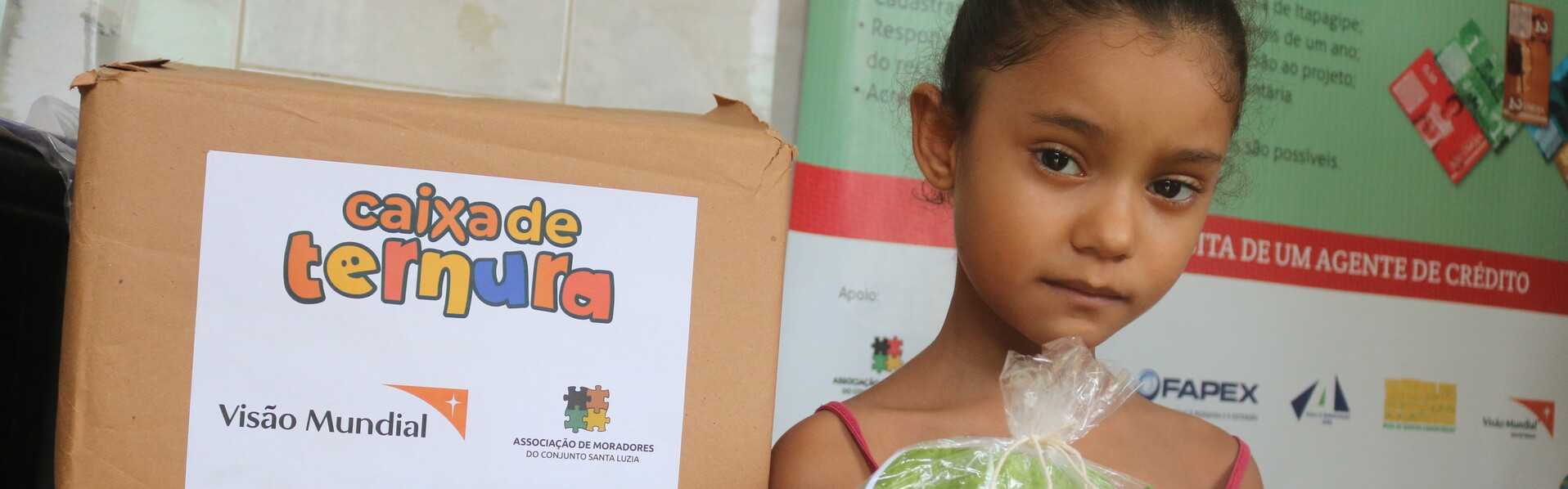 Ein Mädchen in Brasilien hält eine Tüte von der Hilfsorganisation World Vision in der Hand