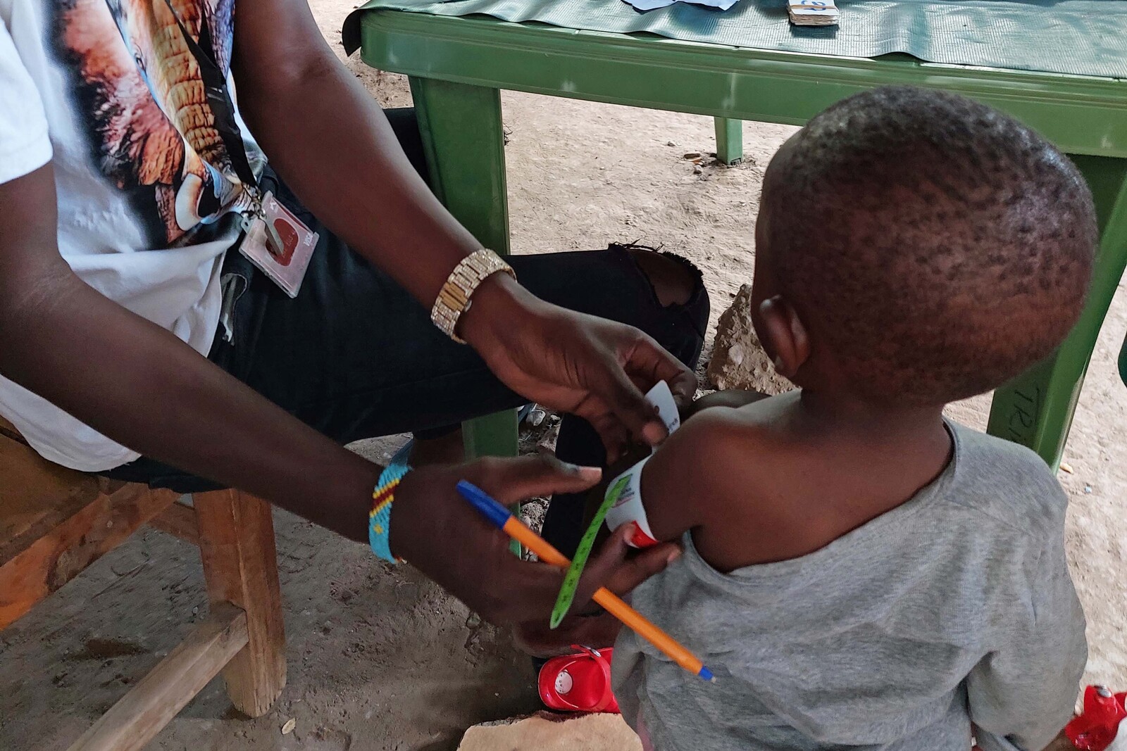 Ein Mann untersucht ein Kleinkind in Kakuma, Kenia