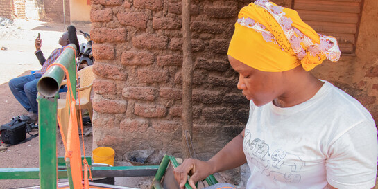 Eine Frau aus Burkina Faso arbeitet am Webstuhl.