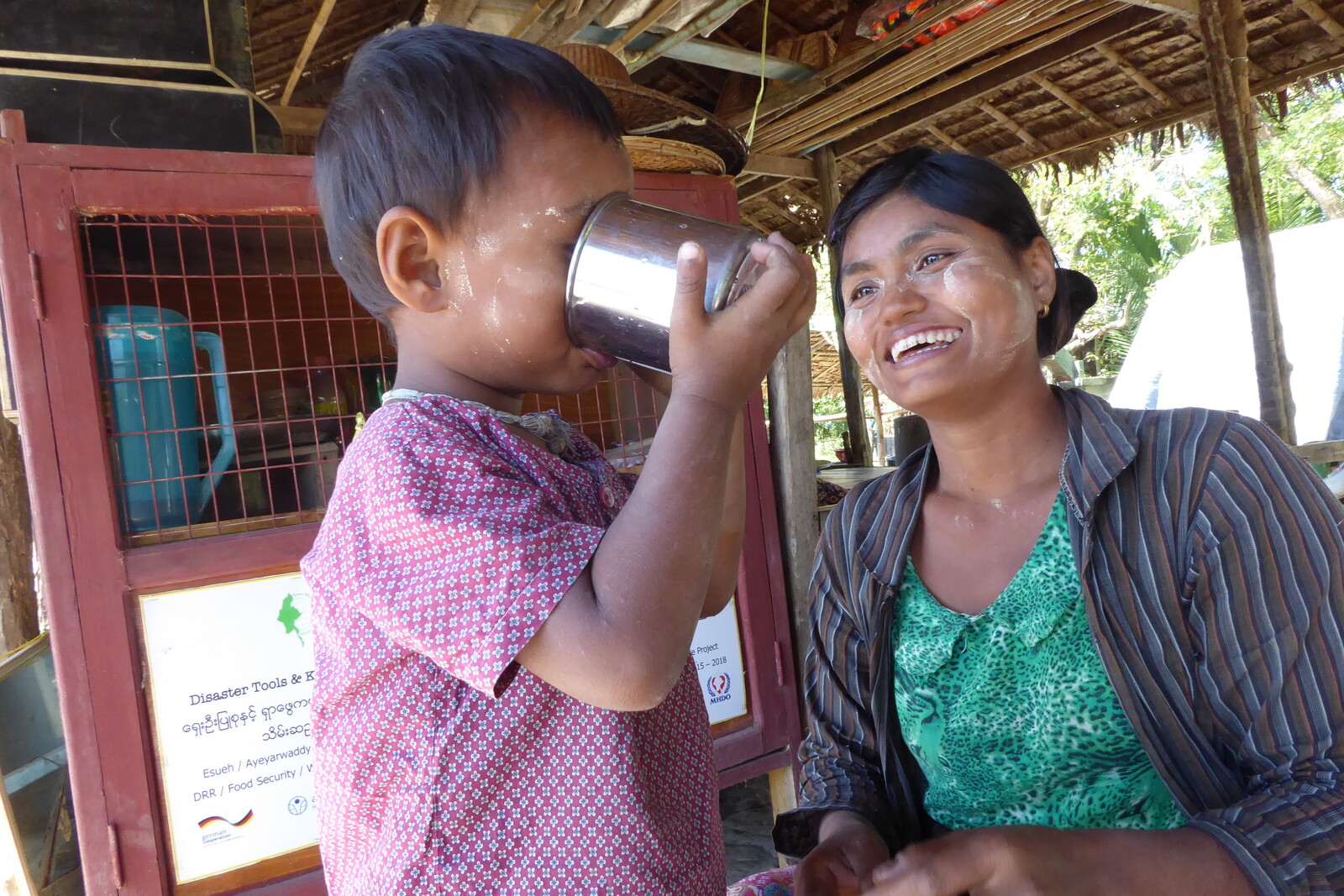 Ein kleiner Junge aus Myanmar trinkt Wasser