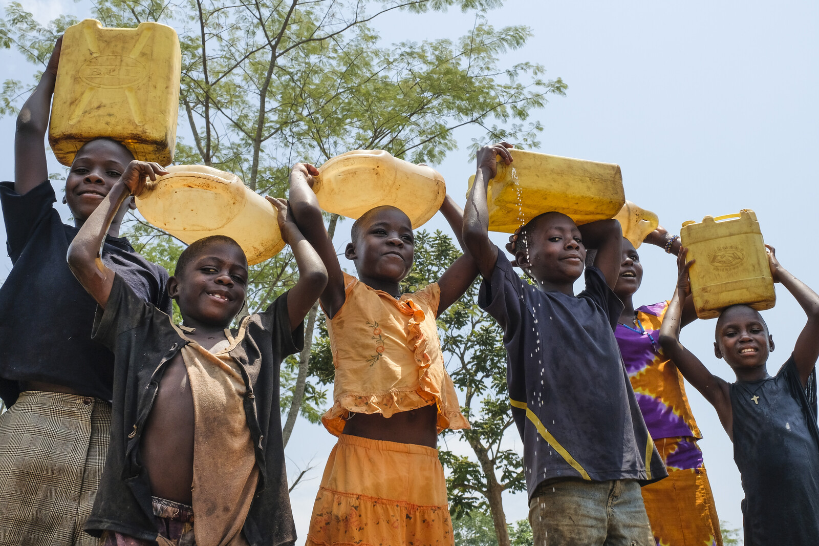 Kinder mit gefüllten Wasserkanistern in Uganda