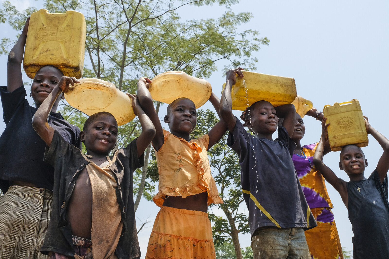 Kinder mit gefüllten Wasserkanistern in Uganda Kinder mit gefüllten Wasserkanistern in Uganda