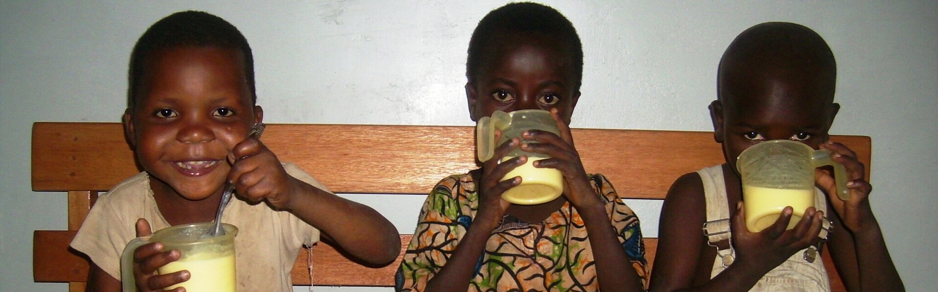 Drei kongolesische Jungen trinken nährstoffreiche Milchnahrung