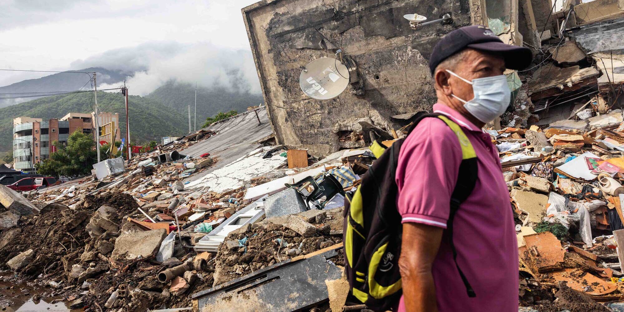 Ein Mann mit Maske läuft nach dem Erdbeben in Venezuela an Trümmern vorbei