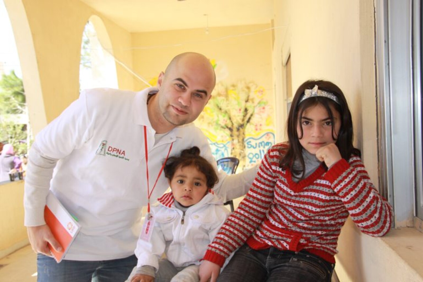 Syrischer Flüchtlingshelfer steht neben Flüchtlingskindern im Libanon.