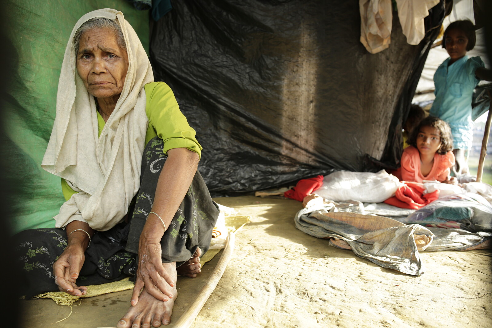 Eine ältere Frau sitzt verzweifelt in einem Zelt nach dem Brand in Cox's Bazar