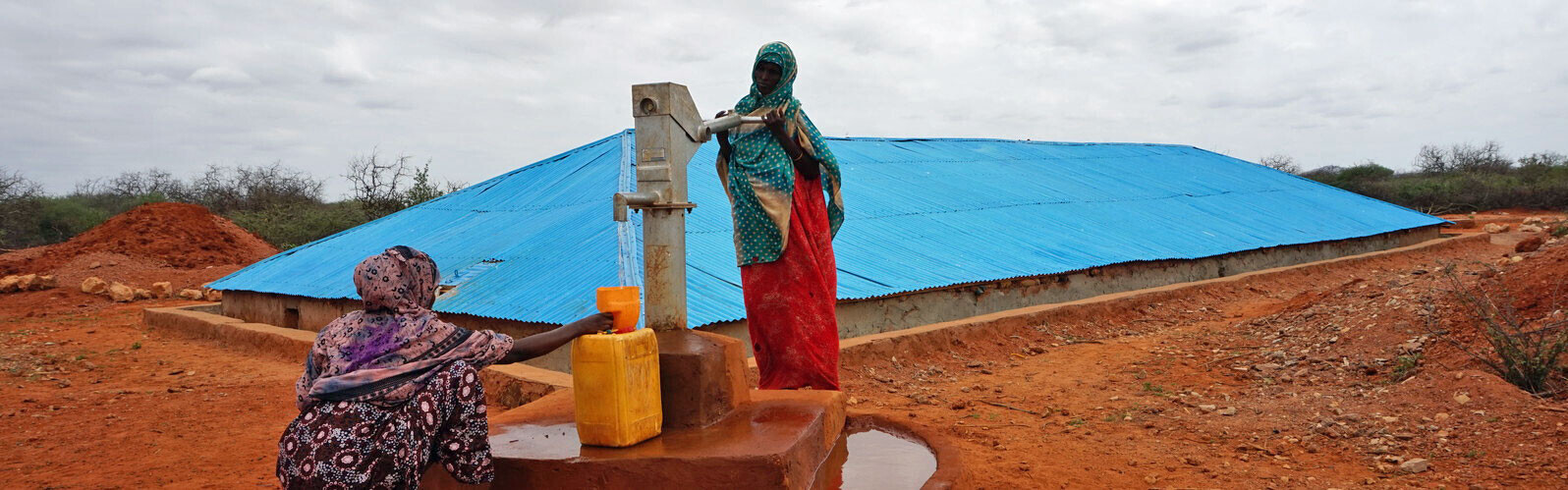 Frauen in Äthiopien füllen aus einem Brunnen Trinkwasser in gelbe Kanister ab