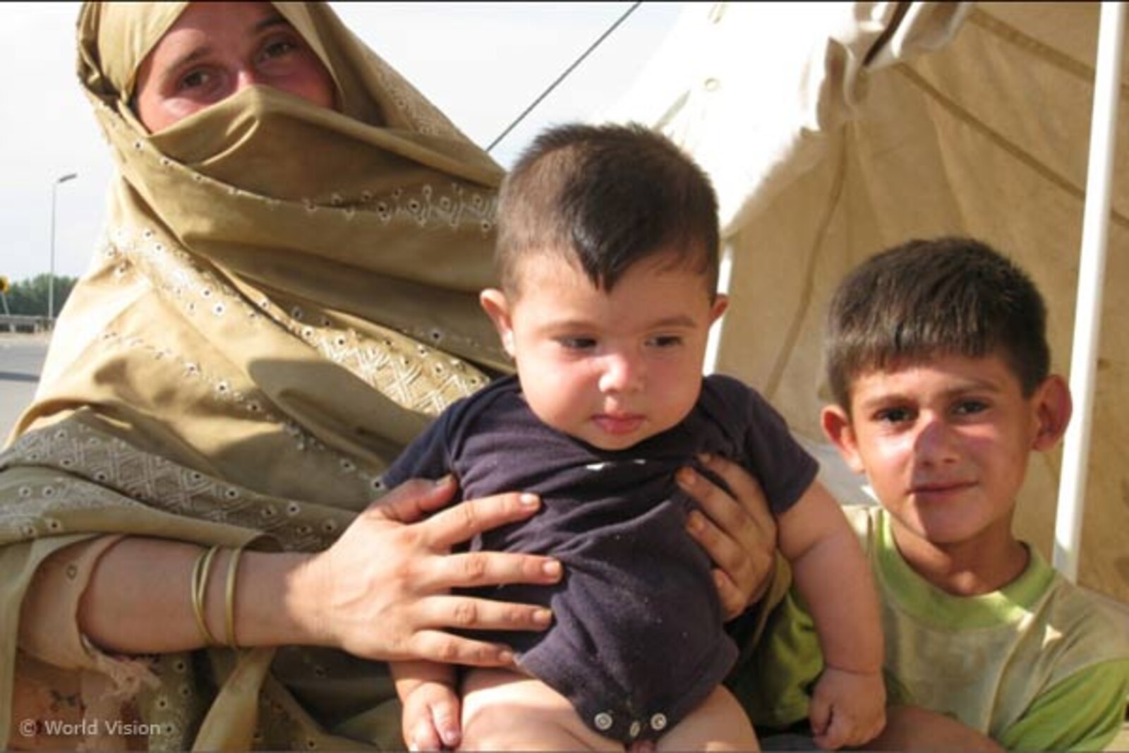fraumitbaby Flut Pakistan: Frau mit zwei Kindern