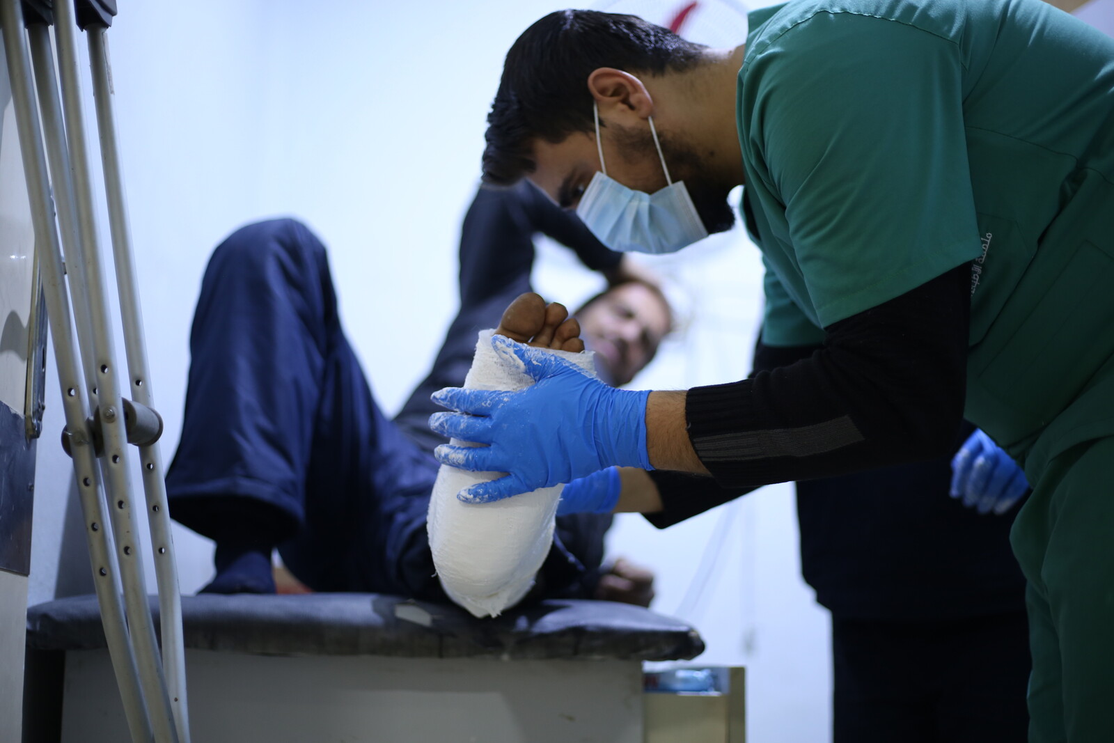 Ein Arzt versorgt den gebrochenen Fuß eines Mannes
