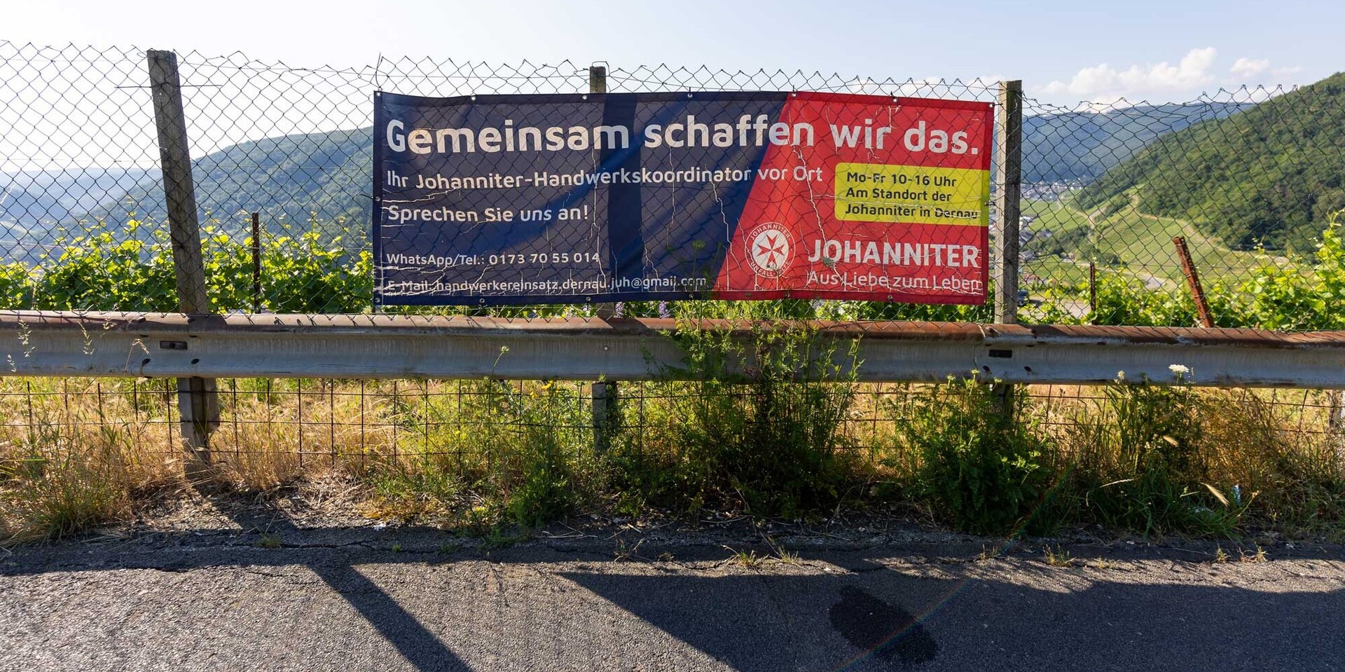 Banner mit Werbung für die Hochwasserhilfe der Johanniter an einer Straße in Richtung Ahrtal 