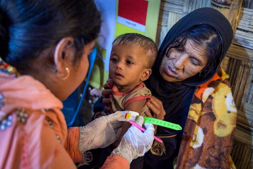 Eine Helferin prüft den Oberarmumfang eines kleinen Kindes im Flüchtlingscamp für Rohingya in Bangladesch Eine Helferin prüft den Oberarmumfang eines kleinen Kindes im Flüchtlingscamp für Rohingya in Bangladesch
