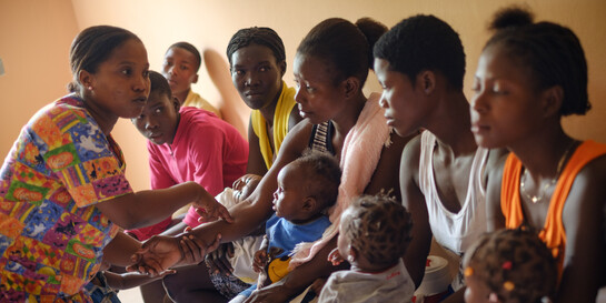 Eine Helferin im Gespräch mit Müttern in Haiti