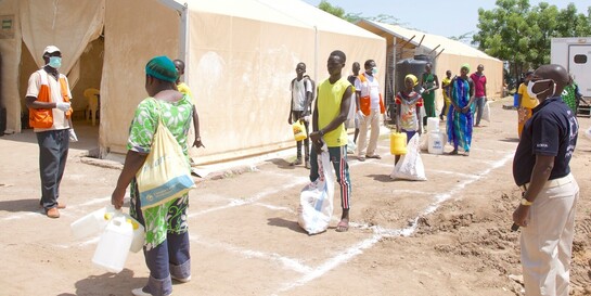 Menschen in Kenia warten auf vor einem Zelt der Hilfsorganisation World Vision auf ihre Lebensmittelrationen 