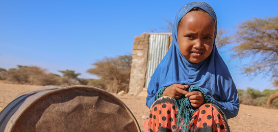 In Somalia sitzt ein Kind auf dem Boden. Es ist von der Hungerkrise in Afrika betroffen