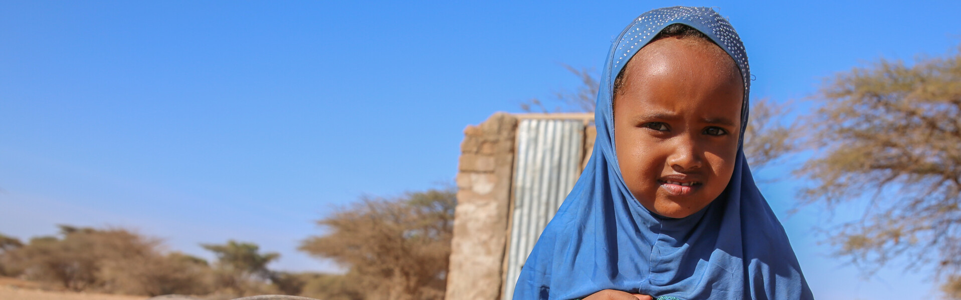 In Somalia sitzt ein Kind auf dem Boden. Es ist von der Hungerkrise in Afrika betroffen