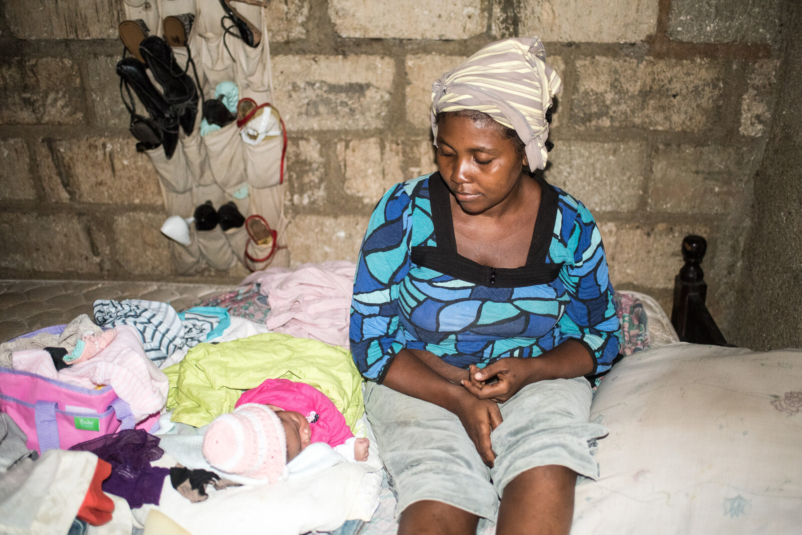 Eine Frau sitzt mit ihrem Baby in einer Baracke in Haiti. Die Not der Menschen ist im ärmsten Land der westlichen Hemisphäre groß.