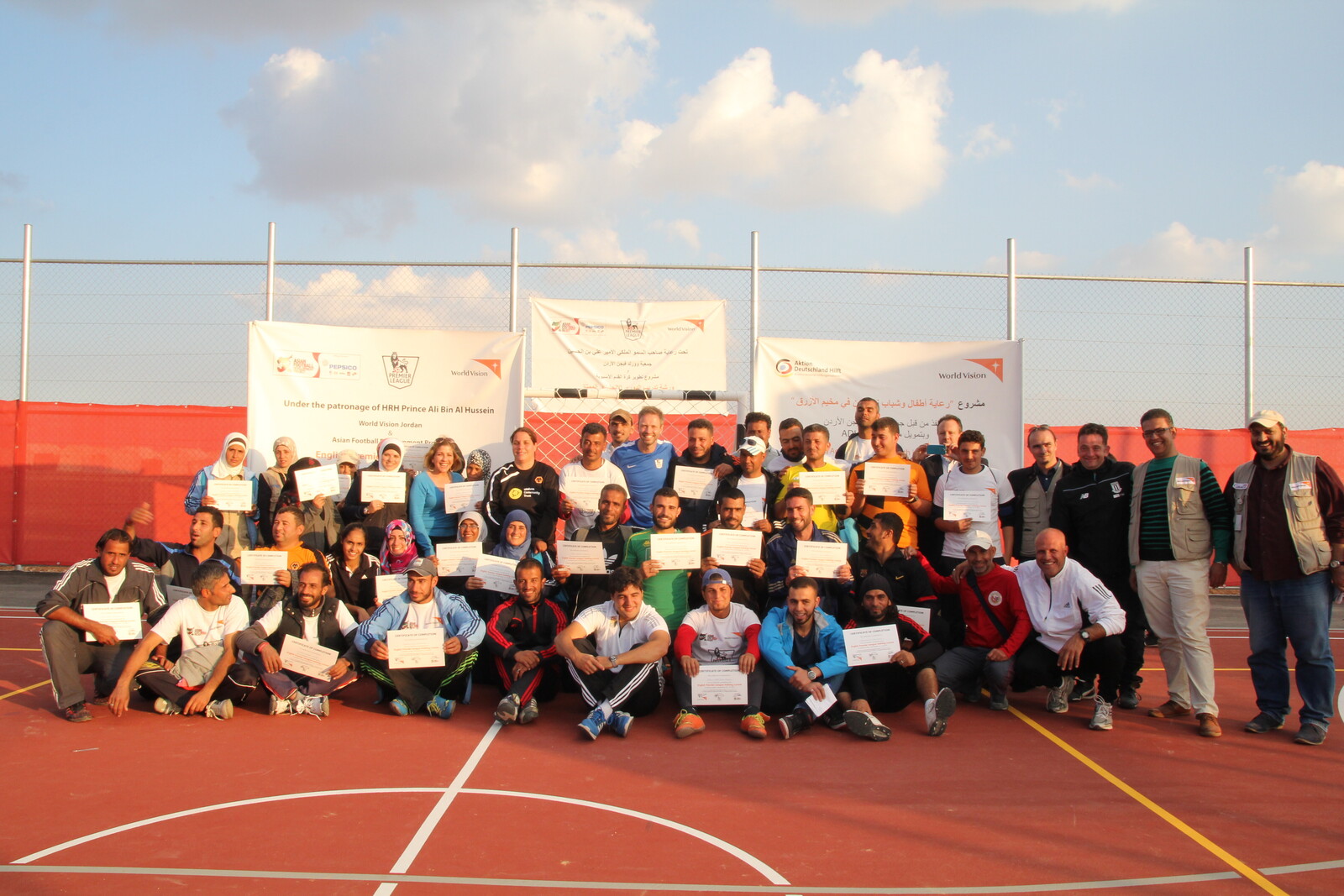 Trainer und Spieler stehen im Flüchtlingscamp Al Azraq für ein Gruppenfoto.