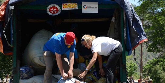 Helfer packen Säcke aus vom Laswagen in Nepal.