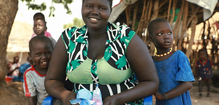Eine junge Frau mit einer wiederverwertbaren Binde, die unsere Bündnisorganisation Malteser International verteilt hat. Etwa 80% der Flüchtlinge in Rhino sind Frauen und Kinder.