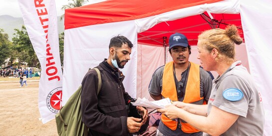 Zwei Helfer:innen nehmen die Daten einer Person auf, die von dem Erbeben in Venezuela betroffen ist