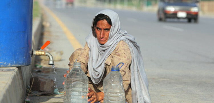 Flut Pakistan: Frau holt Wasser