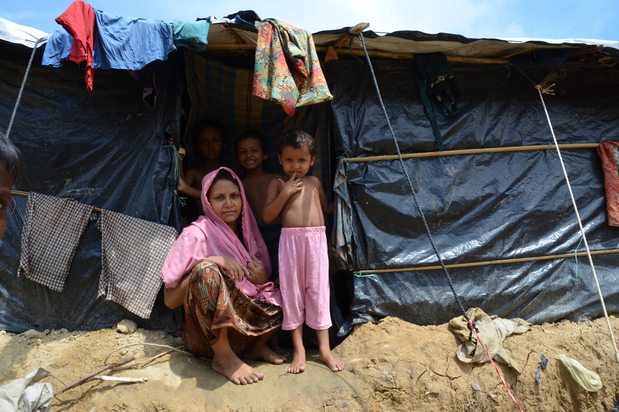 Eine Frau mit ihren Kindern vor einer Notunterkunft für Rohingya-Flüchtlinge in Bangladesch Eine Frau mit ihren Kindern vor einer Notunterkunft für Rohingya-Flüchtlinge in Bangladesch