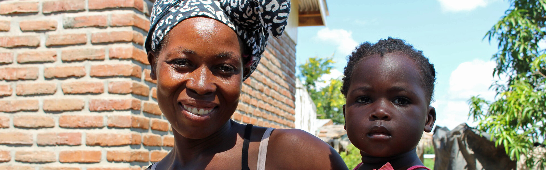 Eine Frau im afrikanischen Chikwawa trägt ihre Tochter auf dem Arm