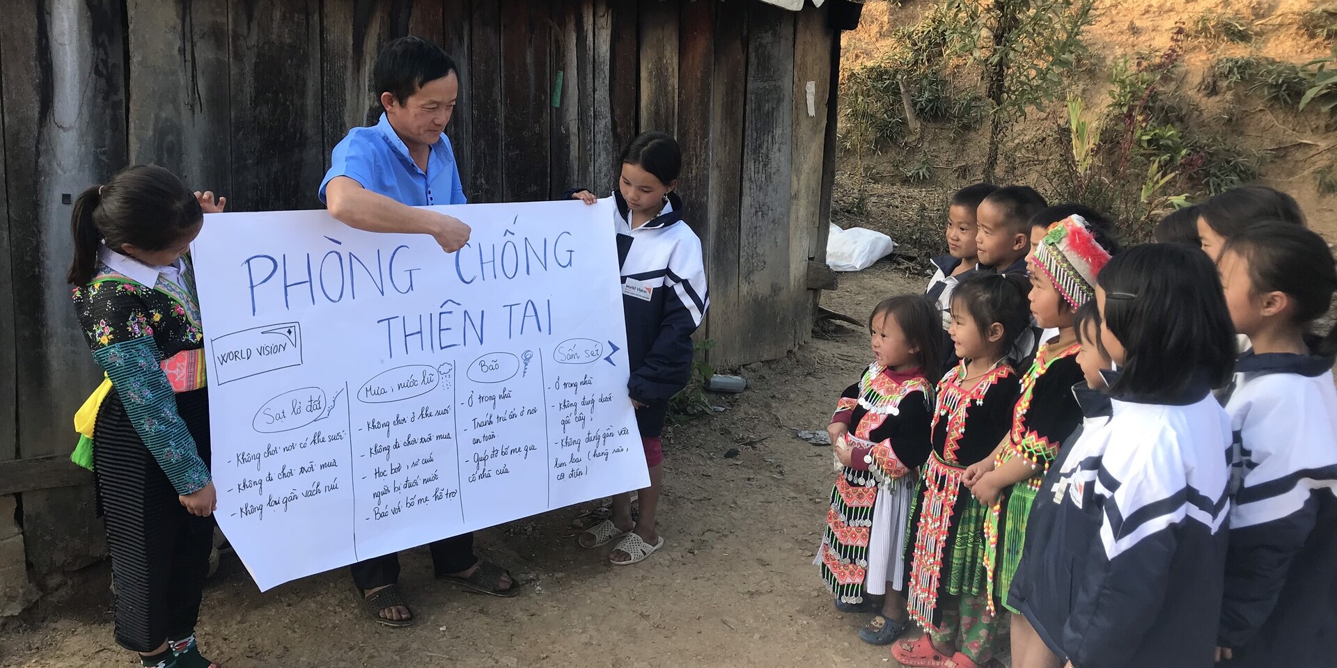 Ein Helfer von World Vision unterrichtet Kinder in einer vietnamesischen Schule richtiges Verhalten bei einer Naturkatastrophe