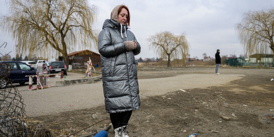 Eine aus der Ukraine geflüchtete Frau blickt traurig auf den Boden