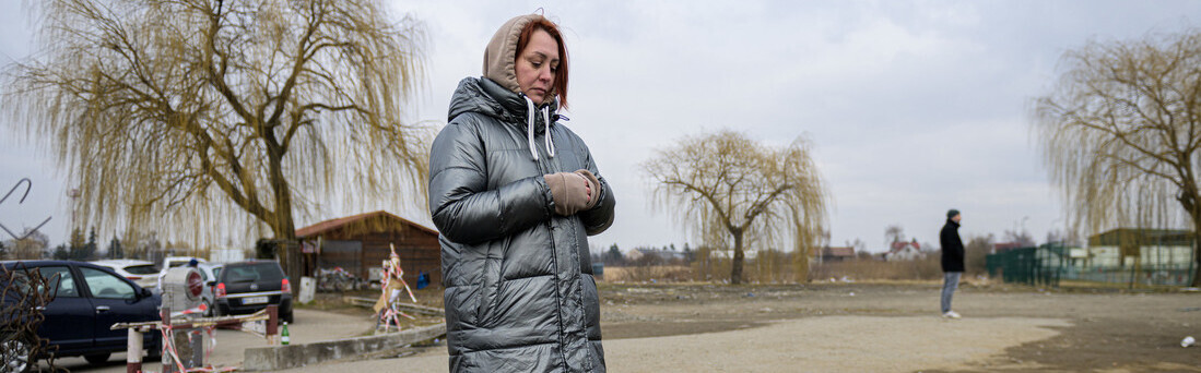 Eine aus der Ukraine geflüchtete Frau blickt traurig auf den Boden