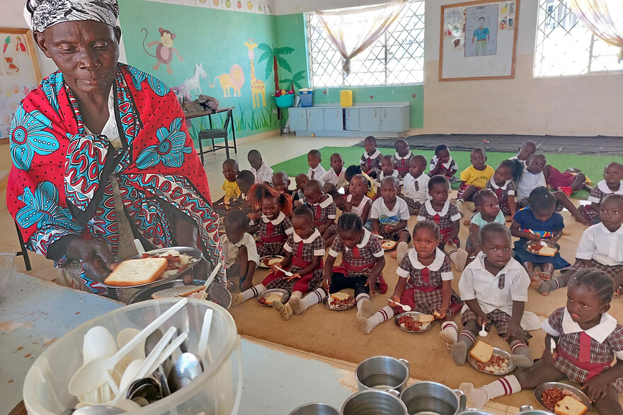 Eine Schulklasse sitzt zum Essen auf dem Boden Eine Schulklasse sitzt zum Essen auf dem Boden