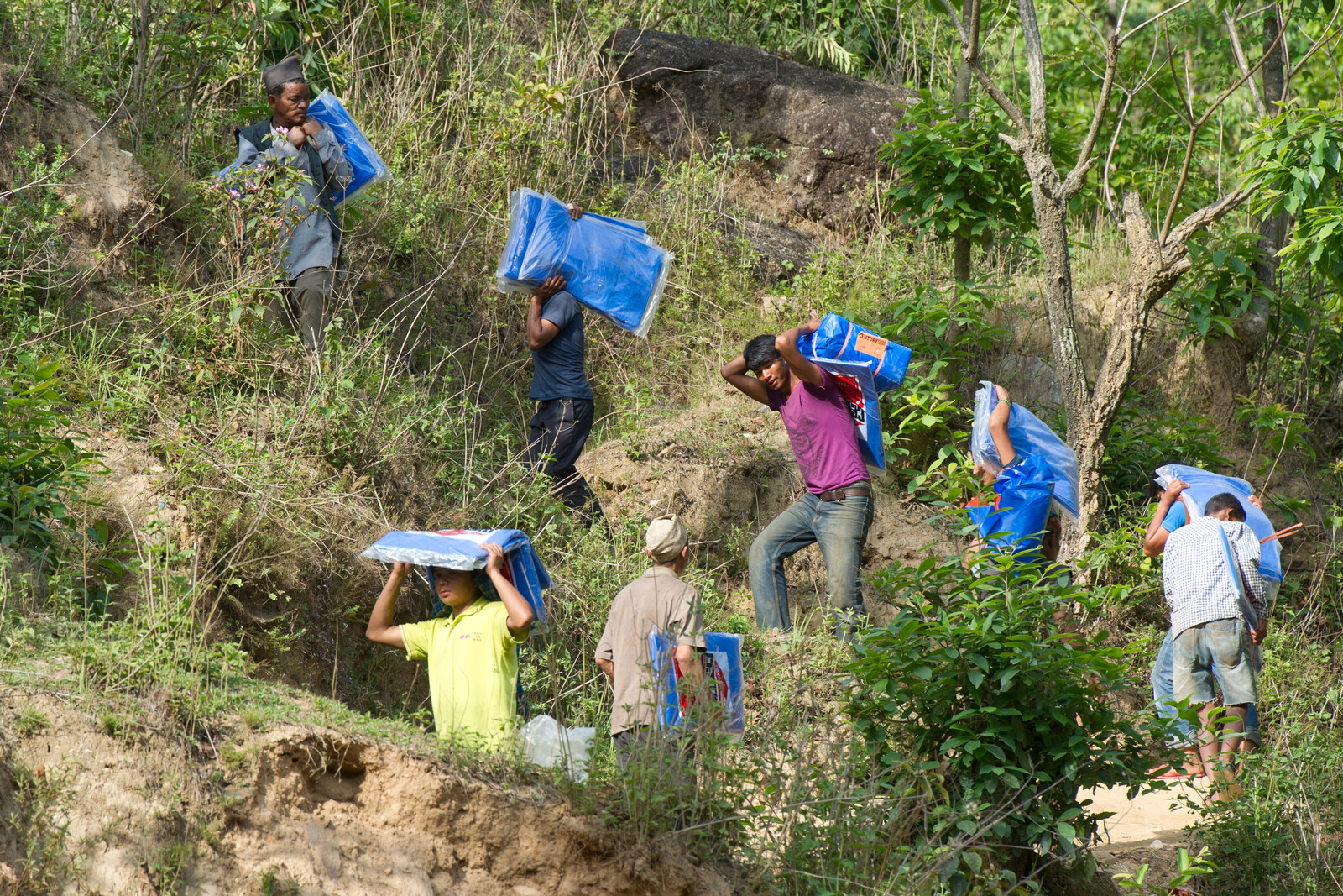 Helfer tragen Säcke durch Nepal nach dem Erdbeben.