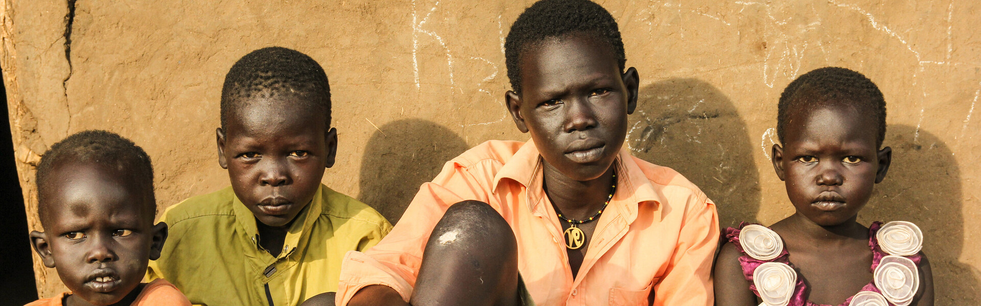 In Uganda sitzt eine Flüchtlingsfamilie. Sie sind Flüchtlinge aus Südsudan.