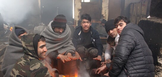 Flüchtlinge auf dem Balkan wärmen sich bei Minusgraden an einem Feuer auf.
