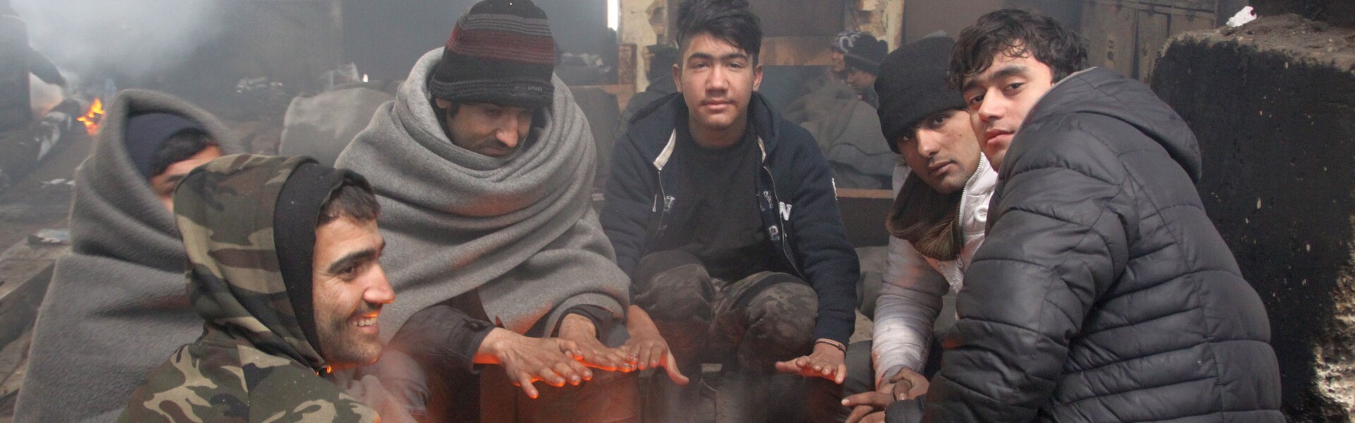 Flüchtlinge auf dem Balkan wärmen sich bei Minusgraden an einem Feuer auf.