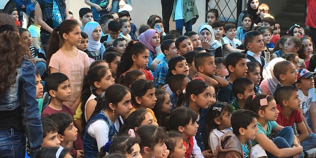 Eine Gruppe von Kindern, die aus Syrien geflüchtet sind Eine Gruppe von Kindern schaut gebannt auf das Geschehen vor ihnen