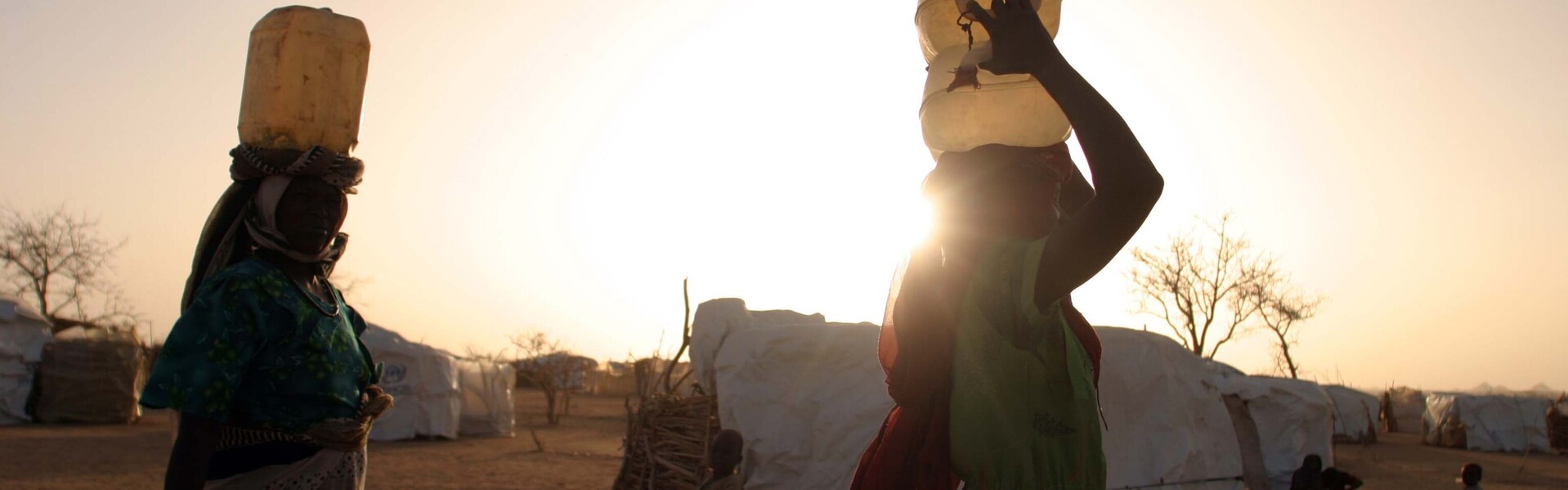 Zwei Menschen tragen im Sudan Wasserkanister (Archivfoto)