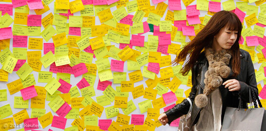 Erdbeben Japan Frau vor eienr Wand mit Postits
