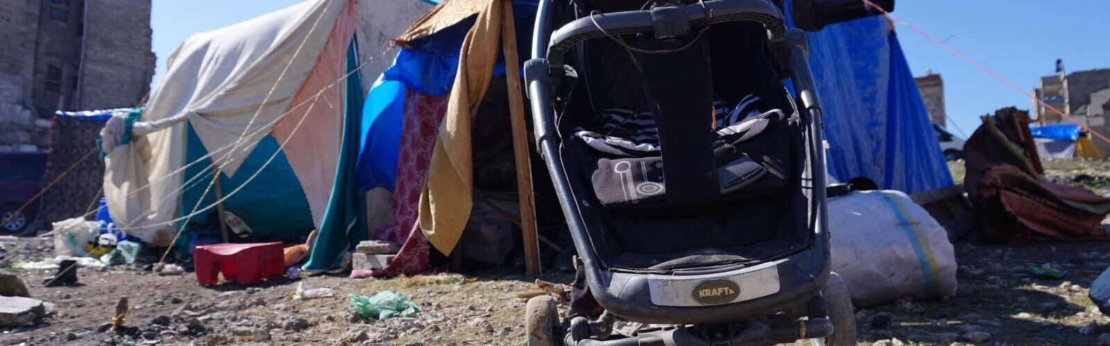 Ein Kinderwagen vor Notunterkünften im Erdbebengebiet