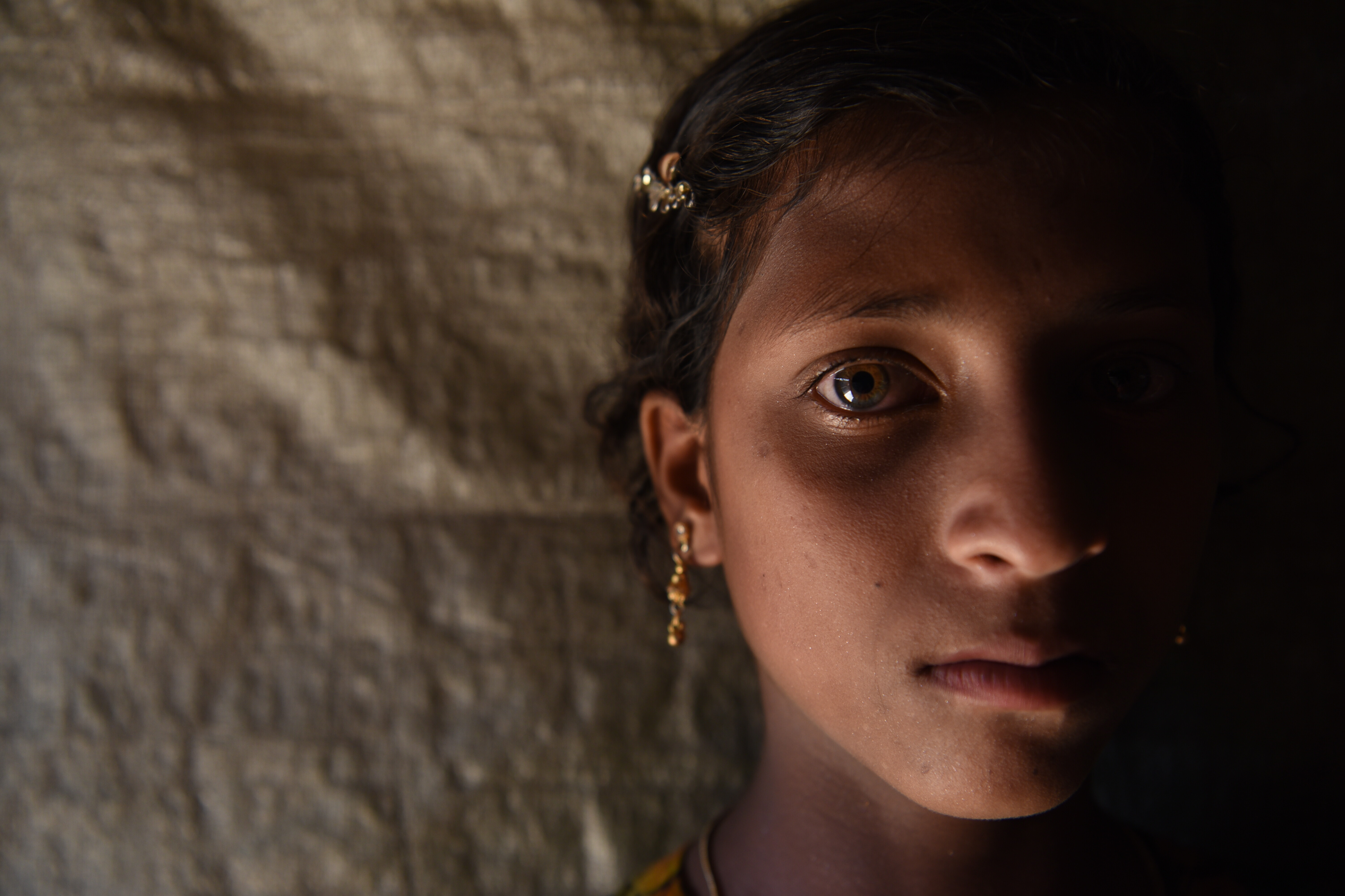 Ein geflüchtetes Rohingya-Mädchen blickt verängstigt in die Kamera
