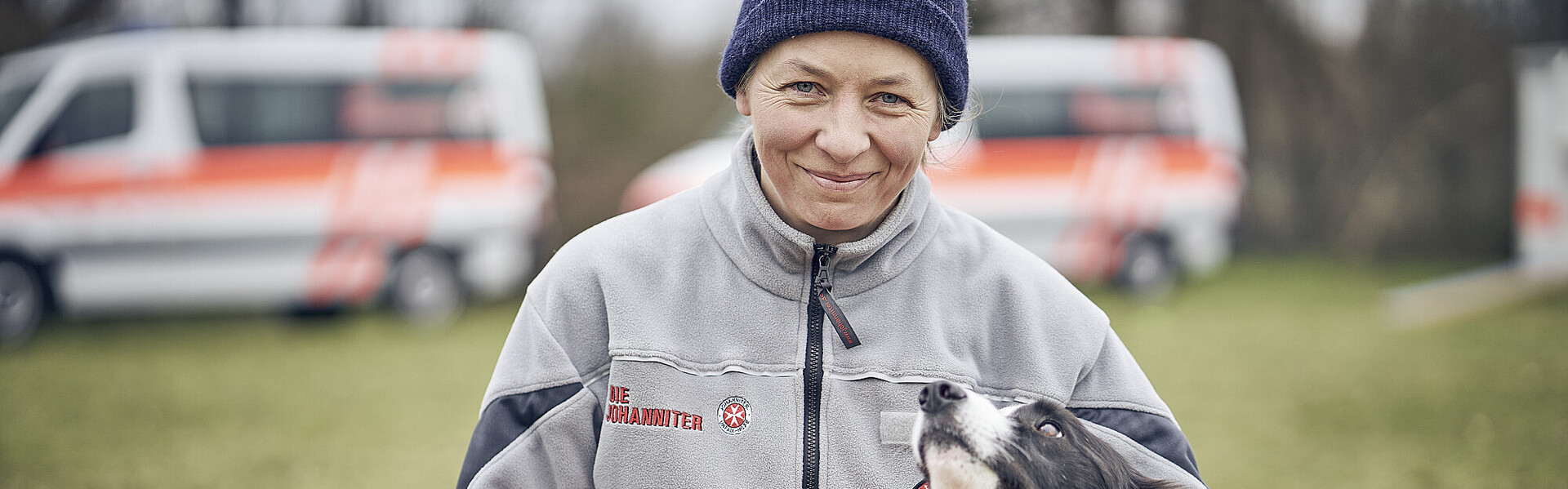 Helferin der Johanniter mit einem Hund im Flutgebiet