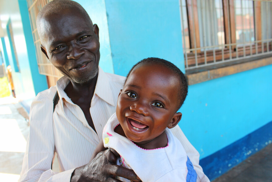In der Demokratischen Republik Kongo hält ein Mann ein kleines Kind im Arm