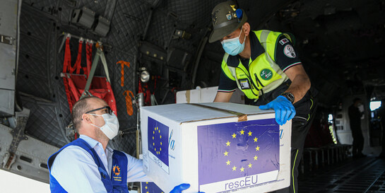 Helfer laden aus einem Militärflugzeug Pakete mit Schutzmasken gegen die Corona-Pandemie aus