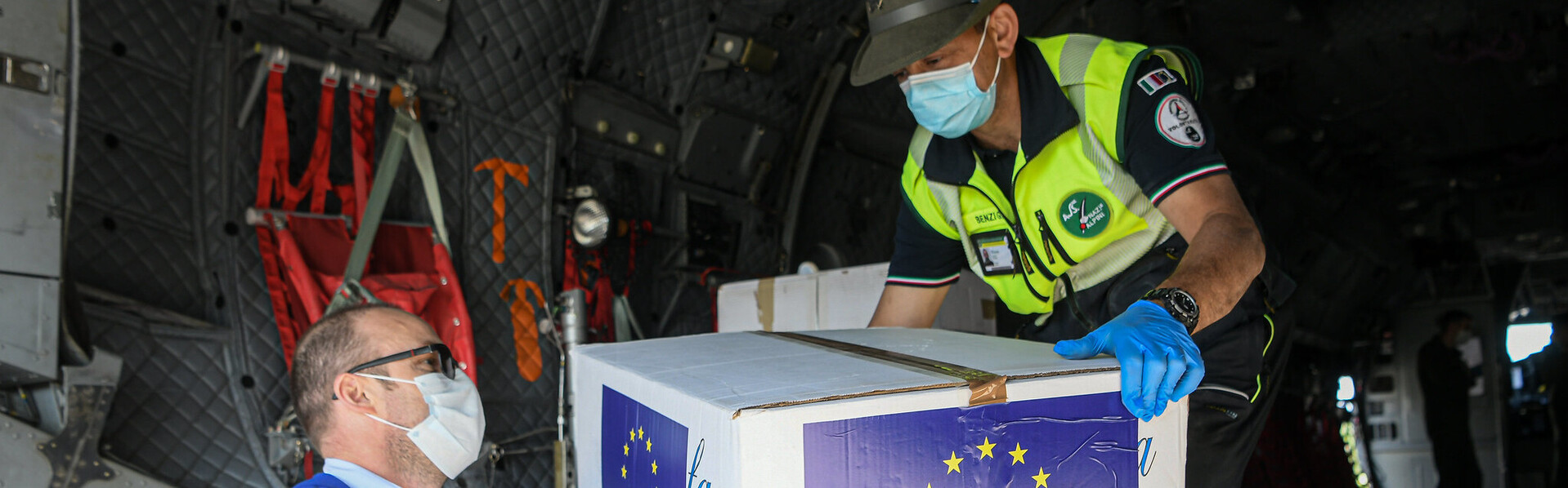 Helfer laden aus einem Militärflugzeug Pakete mit Schutzmasken gegen die Corona-Pandemie aus