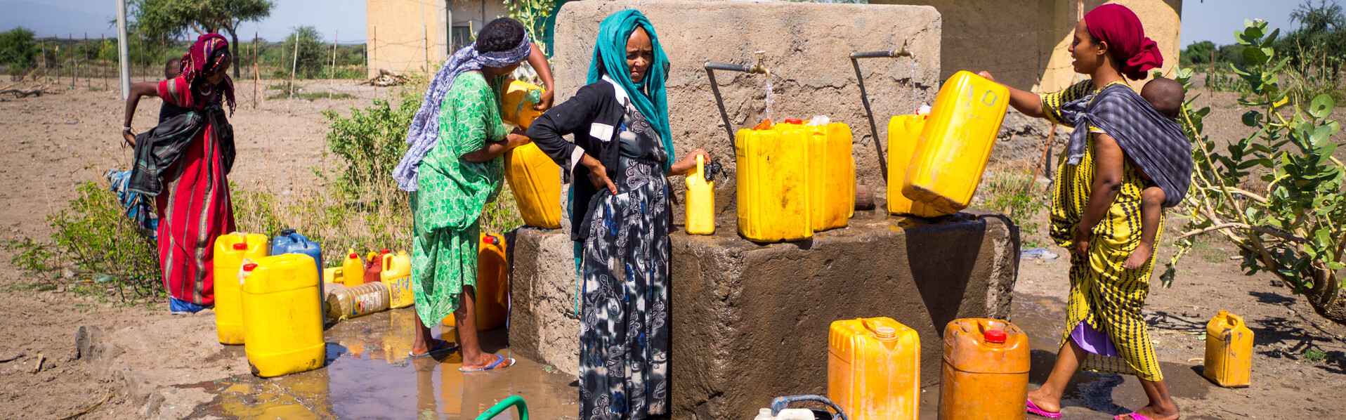 Frauen in der äthiopischen Afar-Region füllen an einem Brunnen sauberes Trinkwasser in Kanister
