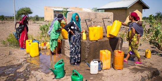 Frauen in der äthiopischen Afar-Region füllen an einem Brunnen sauberes Trinkwasser in Kanister