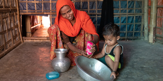 Frau und Kind beim Händewaschen, Corona-Prävention in einem Flüchtlingscamp in Bangladesch