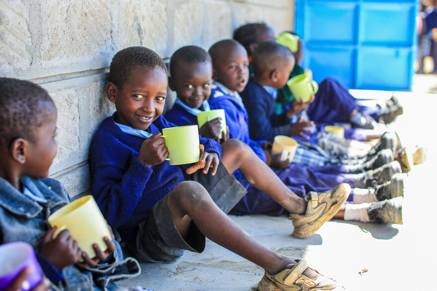 Schulkinder in Kenia mit einem gelben Becher in der Hand Schulkinder in Kenia mit einem gelben Becher in der Hand