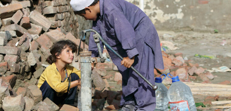 Flut Pakistan: Kinder holen Wasser an alter Handpumpe