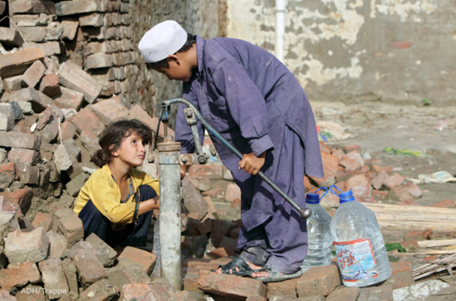 Flut Pakistan: Kinder holen Wasser an alter Handpumpe
